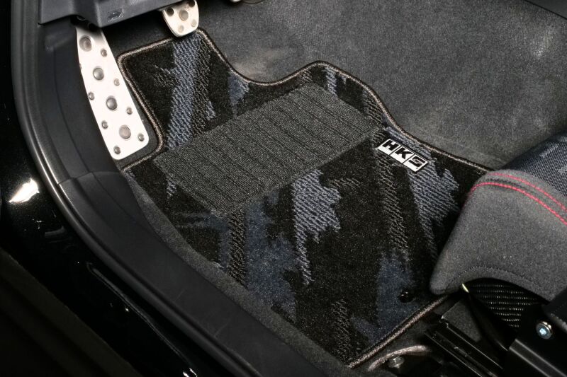 HKS carpeted floor mats full set for October LHD vehicle, showing textured black rubber and branded HKS logo.