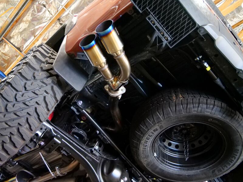 HKS Legamax Trail Master catback axle-back exhaust system on a 2022 Toyota Tundra, showing the stainless steel muffler and pipes.