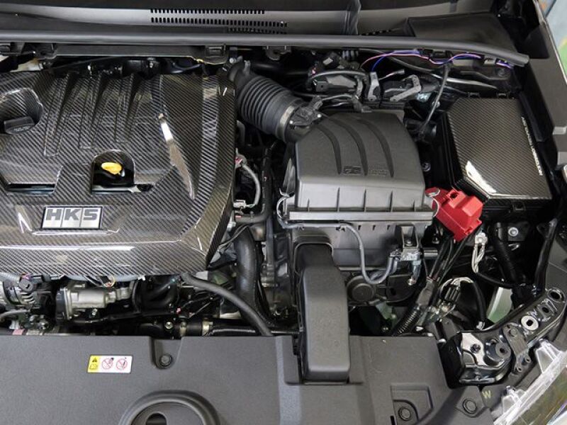 HKS 2023 Toyota GR Corolla dry carbon engine bay fuse box cover, lightweight and durable carbon fiber panel for engine protection.
