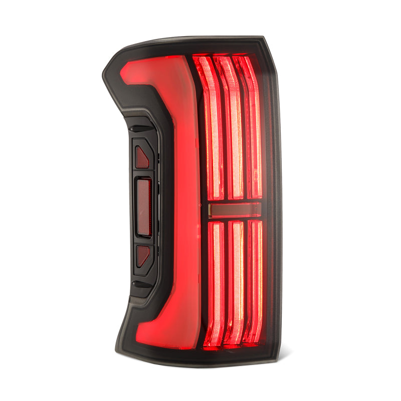 AlphaRex Alpha-Black Nova-Series LED prismatic tail lights on a Toyota Tacoma 24-25 model, showcasing sleek black finish and bright illumination.