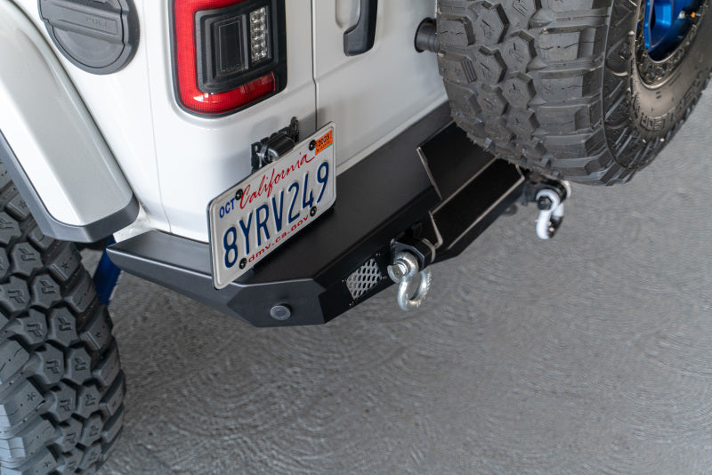 Steel rear bumper for 2018 Jeep Wrangler JL by DV8 Offroad with optional tire carrier, rugged off-road vehicle accessory.