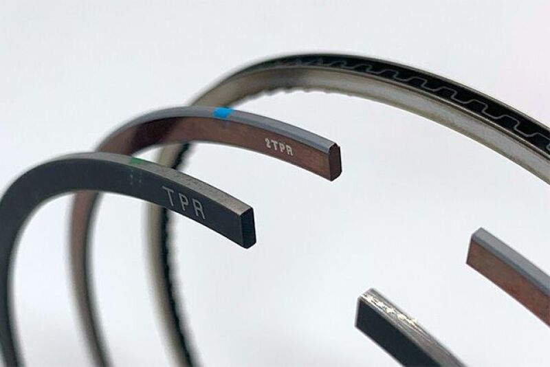 HKS piston ring set N19 D87.0 for 4-cylinder engine, includes high-performance piston rings with detailed metal finish.