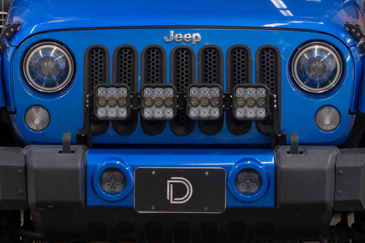 Diode Dynamics Jeep JK SS5 4-Pod CrossLink grille lightbar kit with yellow combo lights installed on front grille.