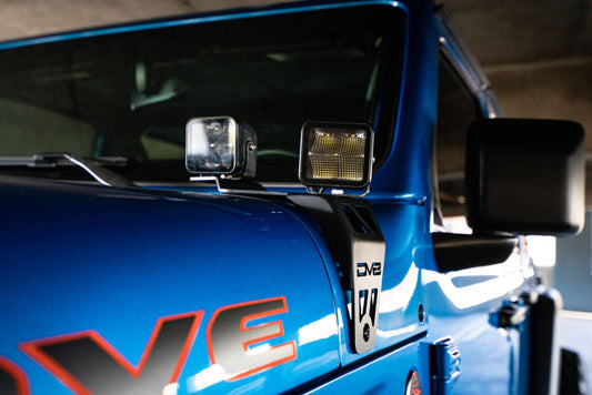 DV8 Offroad Jeep JL 392 and JT Mojave Edition dual pod light mounts mounted on a Jeep vehicle, showcasing rugged off-road accessory.