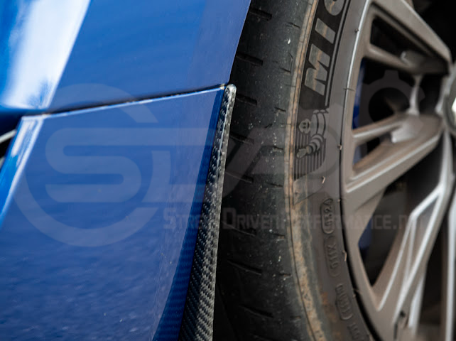 Pair of black carbon fiber mud flaps for 2022-up Cadillac CT5-V Blackwing, designed to protect the vehicle’s front and rear splash areas.