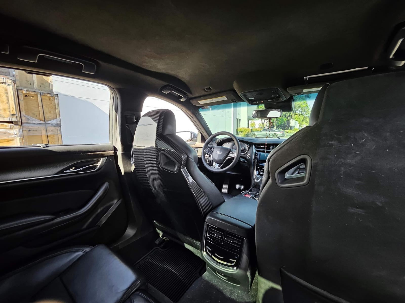 Cadillac ATS-V sedan Recaro carbon fiber seat rear panel cover replacement, showing driver and passenger side seats with carbon fiber finish.