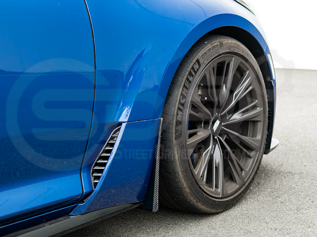 Pair of black carbon fiber mud flaps for 2022-up Cadillac CT5-V Blackwing, designed to protect vehicle sides from road debris.