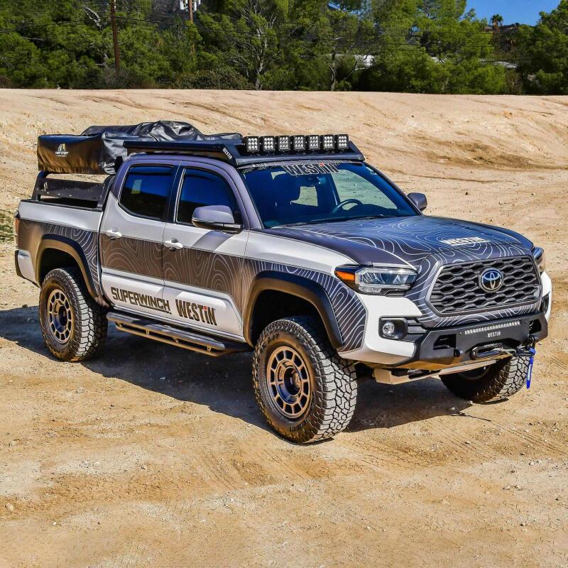 Westin roof rack for Toyota Tacoma 2016-2023, mounted on the roof, durable black metal construction for cargo carrying.