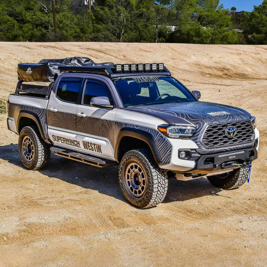 Westin roof rack for Toyota Tacoma 2016-2023, mounted on the roof, durable black metal construction for cargo carrying.