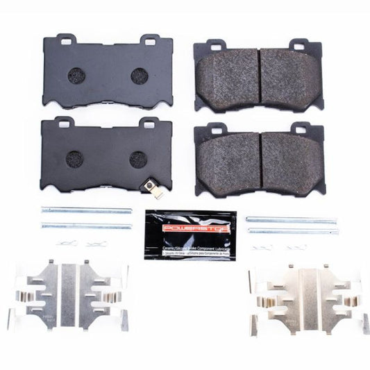 PowerStop racing front brake pads for Infiniti FX50 (2009-2013) with visible metal backing and brake pad friction material.