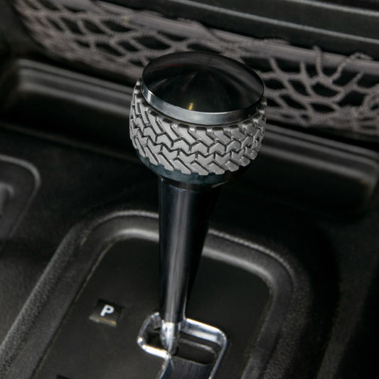 Black DV8 Offroad automatic shift knob for 2011-2018 Jeep JK with a sleek design and easy grip.