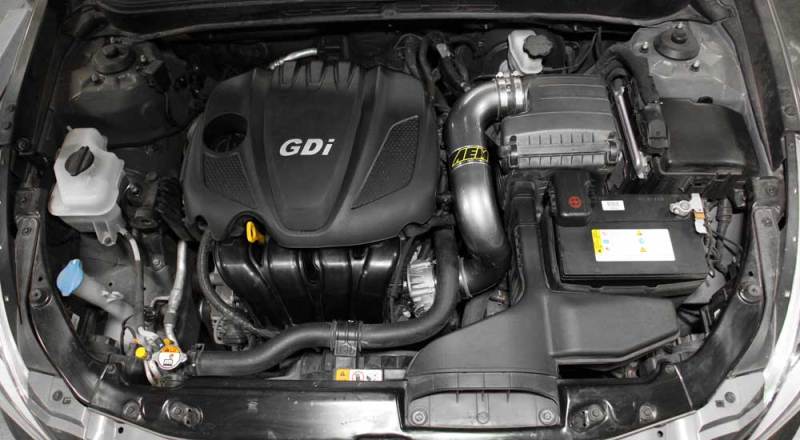 AEM Induction chrome cold air intake installed in a 2006-2009 Honda Civic Si engine bay, showcasing sleek metal tubing and filter.