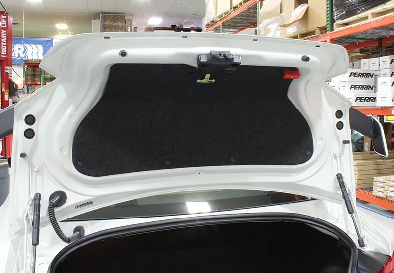 Red Perrin Performance trunk handle for Subaru BRZ, Toyota GR86, and 86/FR-S hatchback, mounted on the car's trunk lid.