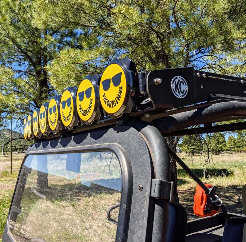 Yellow and black KC HiLiTES 6-inch gravity Pro6 LED light cover with smiley face design and KC logo for protection and style.