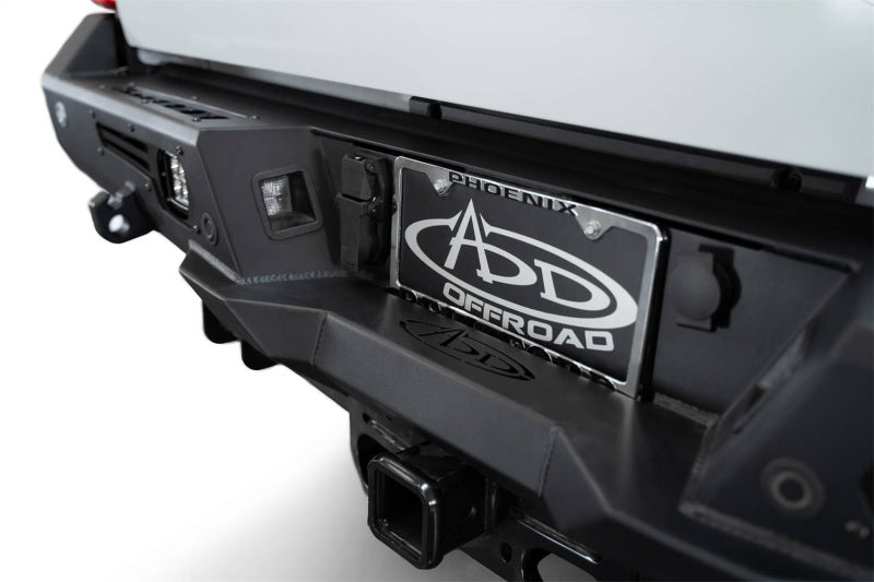 Addictive Desert Designs steel bomber rear bumper on a 2023-2024 Ford F-150 Super Duty pickup truck, showcasing rugged off-road style.