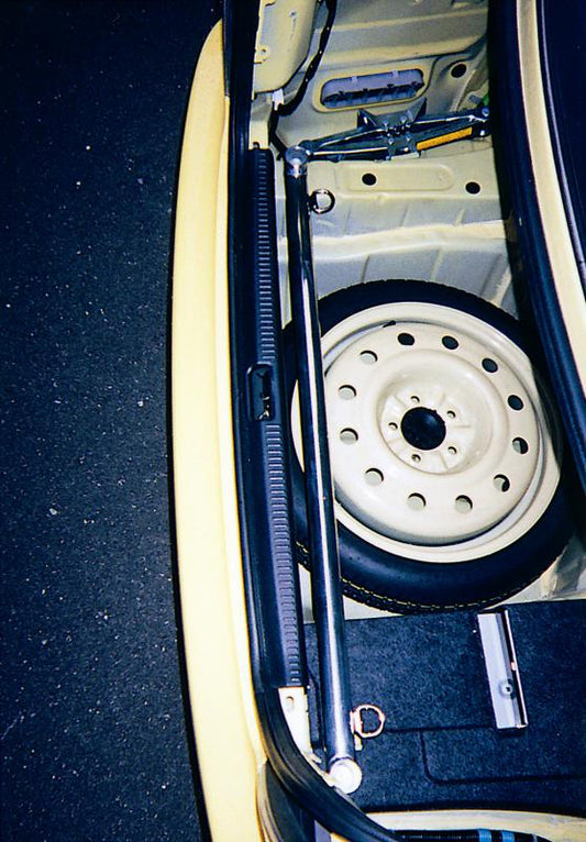 Cusco trunk bar SXE10 IS300 chassis bracing installed in a vehicle, showing the sturdy metal bar reinforcing the trunk area.