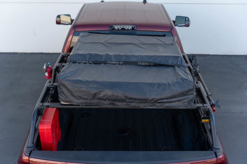 DV8 Offroad MTO Series bed rack for Toyota Tundra and Ford F150 Raptor, adjustable 2-piece truck bed accessory on exterior.