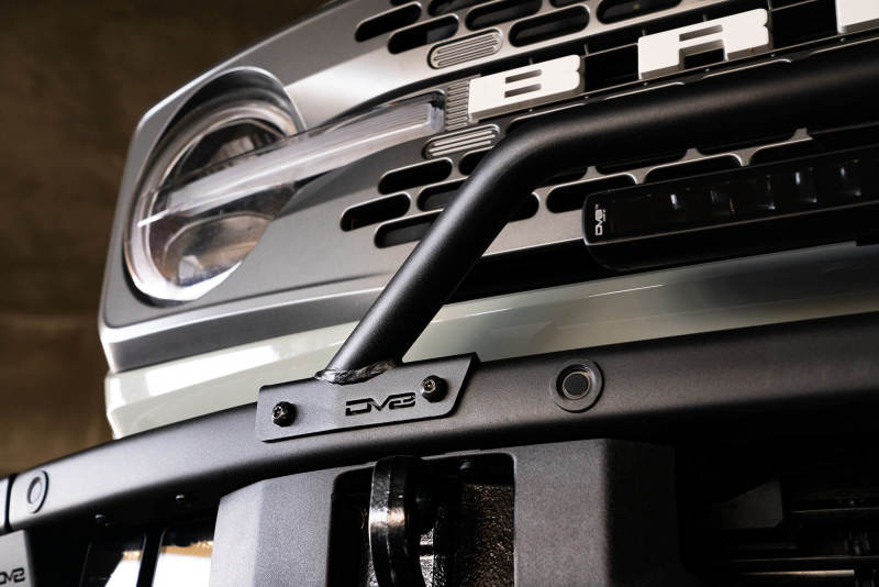 Black DV8 Offroad light mounts for 2021-2022 Ford Bronco factory bumper bull bar, designed for offroad vehicle lighting.