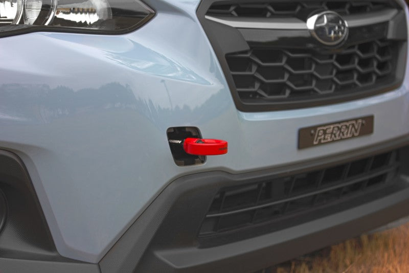 Red Perrin Performance tow hook kit for Subaru WRX, Crosstrek, OBXT, and Impreza front installation, showing the bright red hook.