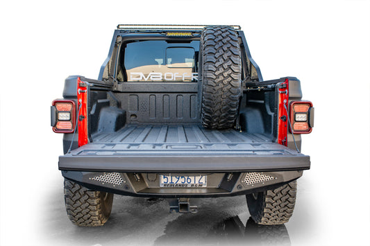 DV8 Offroad Jeep Gladiator universal stand-up in-bed tire carrier mounted on chase rack, suitable for 2019+ models.
