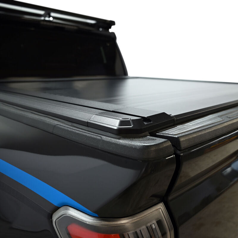 Westin black roll-up tonneau cover for Toyota Tacoma 5ft bed, manual retractable design, enhances truck bed security and style.