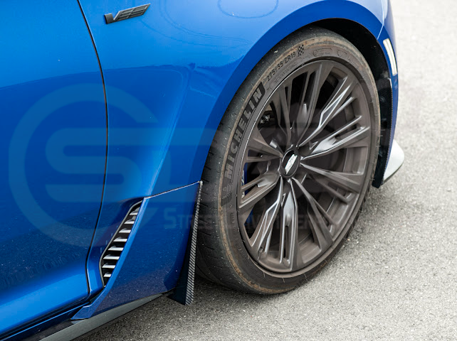 Pair of black carbon fiber mud flaps for 2022-up Cadillac CT5-V Blackwing, designed to protect from road debris.