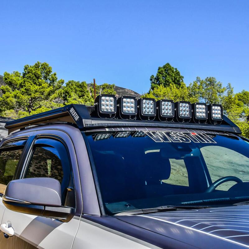 Westin 16-23 Toyota Tacoma Mesa roof rack with black metal bars and mounting brackets on vehicle roof.
