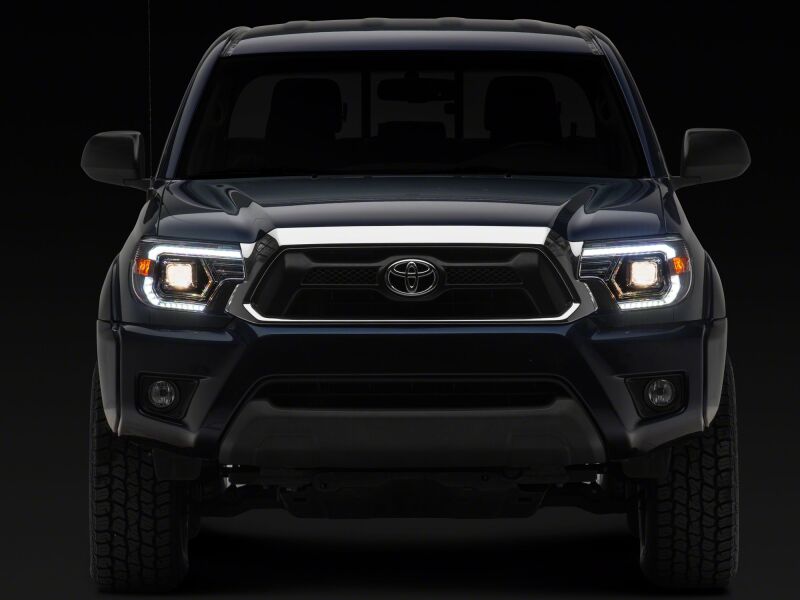 Raxiom 12-15 Toyota Tacoma Axial Series projector headlights in chrome with clear lenses, featuring switchback LED turn signals.