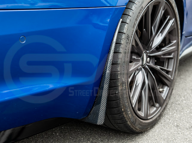 Pair of black carbon fiber mud flaps for 2022-up Cadillac CT5-V Blackwing, featuring Street Driven Performance branding.