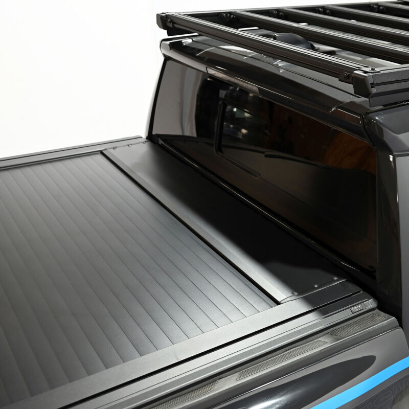Westin 24-26 Toyota Tacoma black roll-up manual retractable tonneau cover on truck bed, designed for easy opening and secure fit.