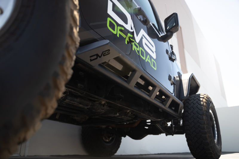 DV8 Offroad 18-23 Jeep Wrangler JL 4-door FS-15 series rock sliders mounted on vehicle body for side protection and off-road durability