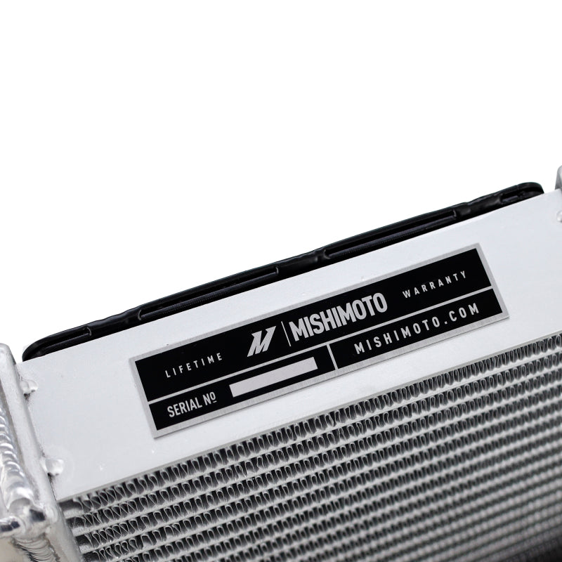 Mishimoto 15-20 BMW F8X M3 M4 performance auxiliary radiator, shown installed in engine bay with metal fins and hoses.