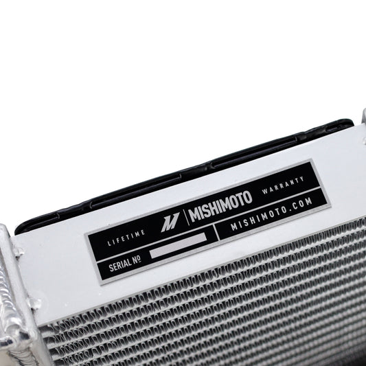 Mishimoto 15-20 BMW F8X M3 M4 performance auxiliary radiator, shown installed in engine bay with metal fins and hoses.