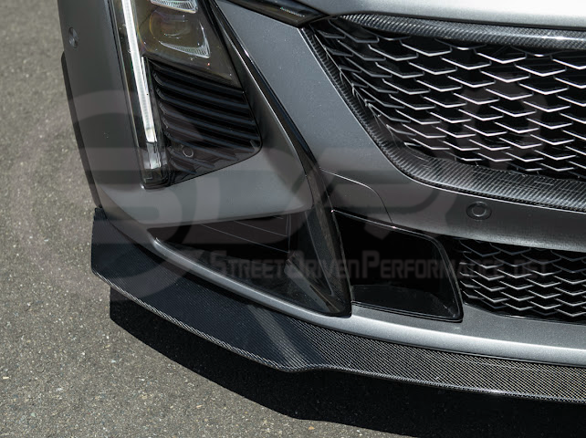 Cadillac CT5-V Blackwing factory OEM style carbon fiber front lip splitter with ground effects and wheel arches, sleek and aggressive design.