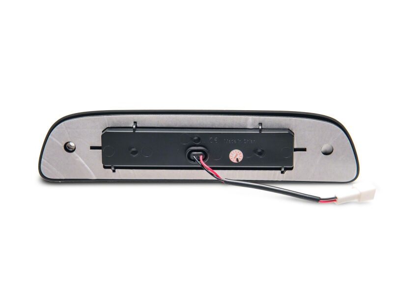 Smoked Raxiom LED third brake light for 2005-2015 Toyota Tacoma Axial Series, mounted on truck rear with clear lens and LED bulbs.