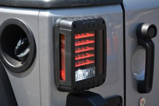 DV8 Offroad Jeep Wrangler JK horizontal LED tail light, 2007-2018, with bright red lens and black housing, mounted on vehicle rear.