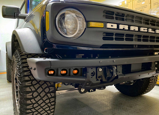 Oracle High 21-22 Ford Bronco triple LED fog lights kit installed on a steel bumper, showcasing bright LED fog light units.