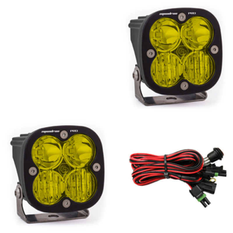 Pair of Baja Designs Squadron Pro LED light pods with amber lenses, designed for driving combo pattern, mounted on a vehicle.