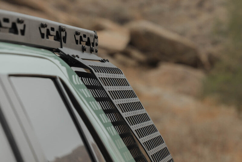 DV8 Offroad exterior trim Molle panel for Toyota 4Runner 25-26 driver side on roof rack, durable black metal with mounting slots.