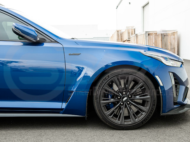 Pair of black carbon fiber mud flaps for 2022-up Cadillac CT5-V Blackwing, designed to protect the vehicle from road debris.