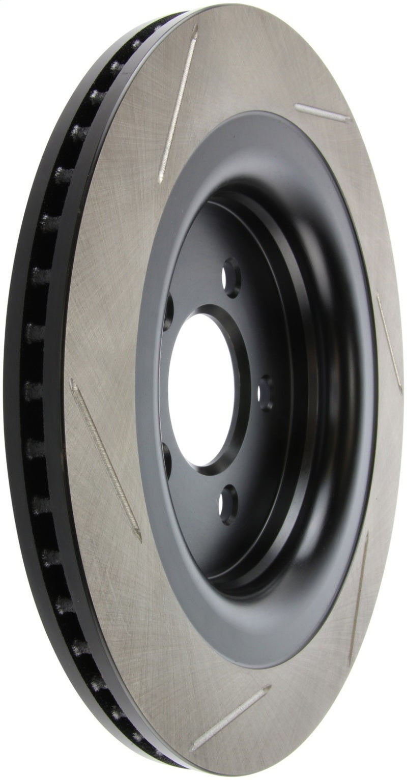 StopTech left rear slotted brake rotor for 2015 Ford Mustang GT with Brembo brakes, showing the metal rotor with slots for heat dissipation.