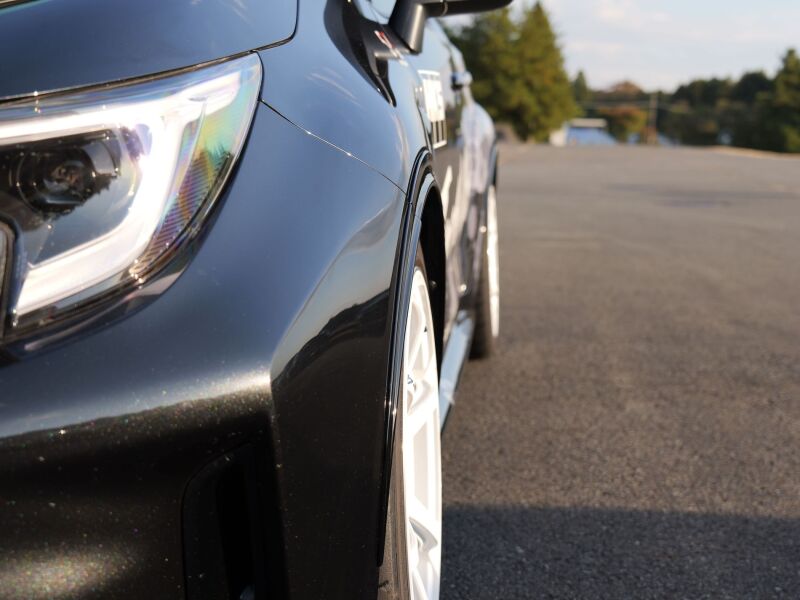 HKS GR Corolla GZEA14H fender molding from body kit, close-up view showing sleek black finish on car's fender.