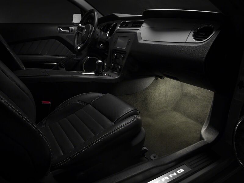 Raxiom Ford Mustang interior LED footwell lighting kit in white, illuminating footwell area inside 2005-2014 Mustang.
