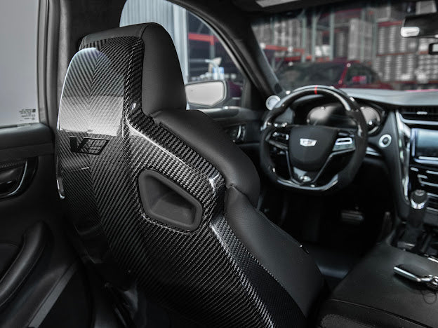 Cadillac ATS-V sedan Recaro carbon fiber seat rear panel cover replacement, front view showing driver and passenger side seats.