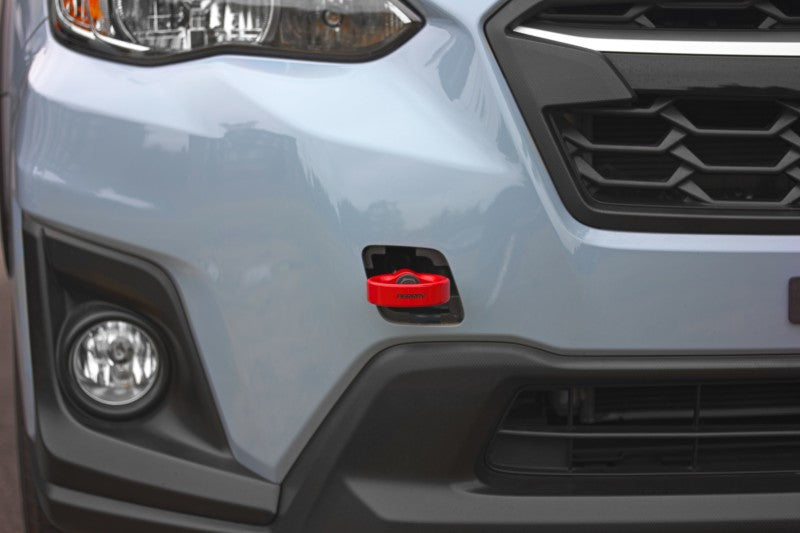 Red Perrin Performance tow hook kit for Subaru WRX, Crosstrek, OBXT, and Impreza front bumper, includes tow hooks and mounting hardware.