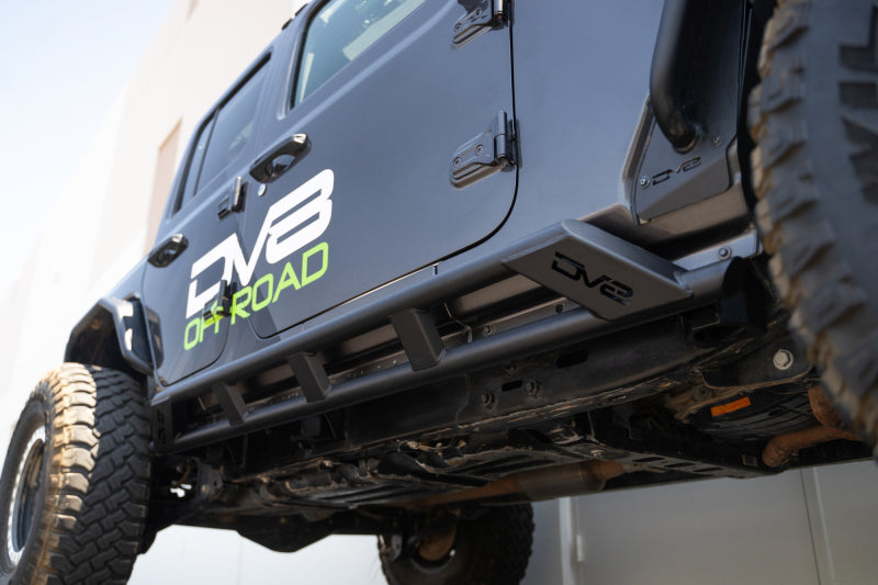 DV8 Offroad 18-23 Jeep Wrangler JL 4-door FS-15 rock sliders mounted on side of vehicle, exterior body armor and rock rails.