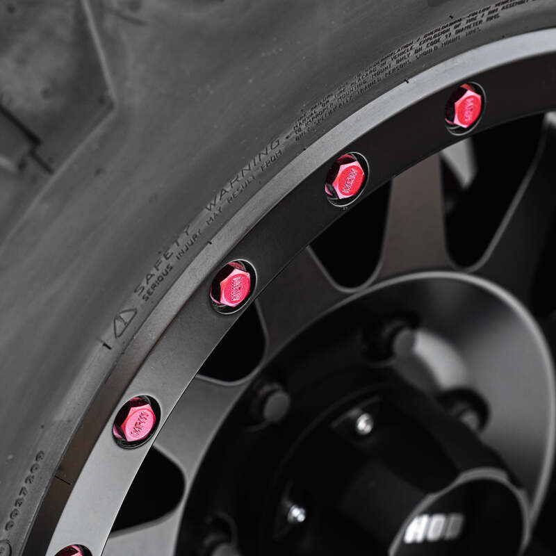 Method Lip Bolt wheel bolts in matte red for street use, shown on a vehicle wheel with a sleek finish and sturdy design.