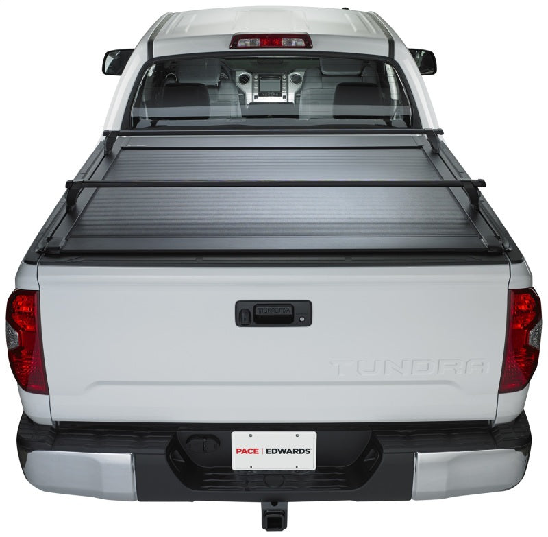 Pace Edwards Ultragroove retractable tonneau cover on Nissan Titan King Cab truck bed, showing sleek black design and installation.
