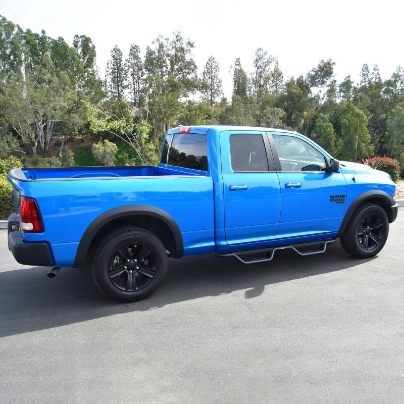 Westin Outlaw Drop Nerf Step Bars in textured black mounted on a Ram 1500 quad cab truck for easy access and protection.