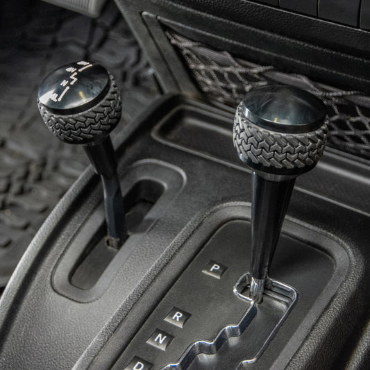 Black DV8 Offroad Jeep JK shift knob for 2011-2018 automatic transmissions, featuring a sleek design and ergonomic grip.